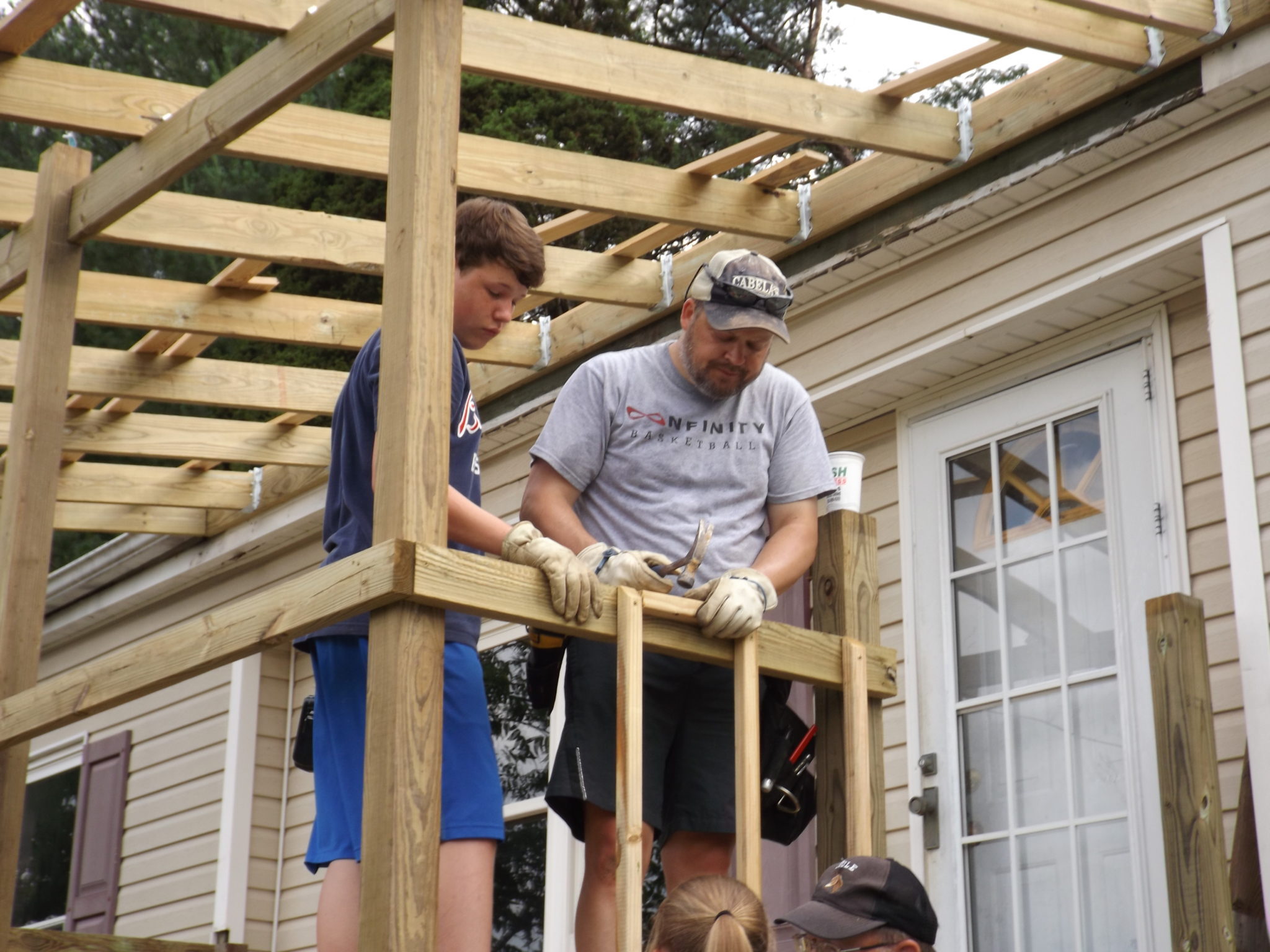 Volunteers for Americans Helping Americans repair a porch and roof as part of the Housing Programs initiative.