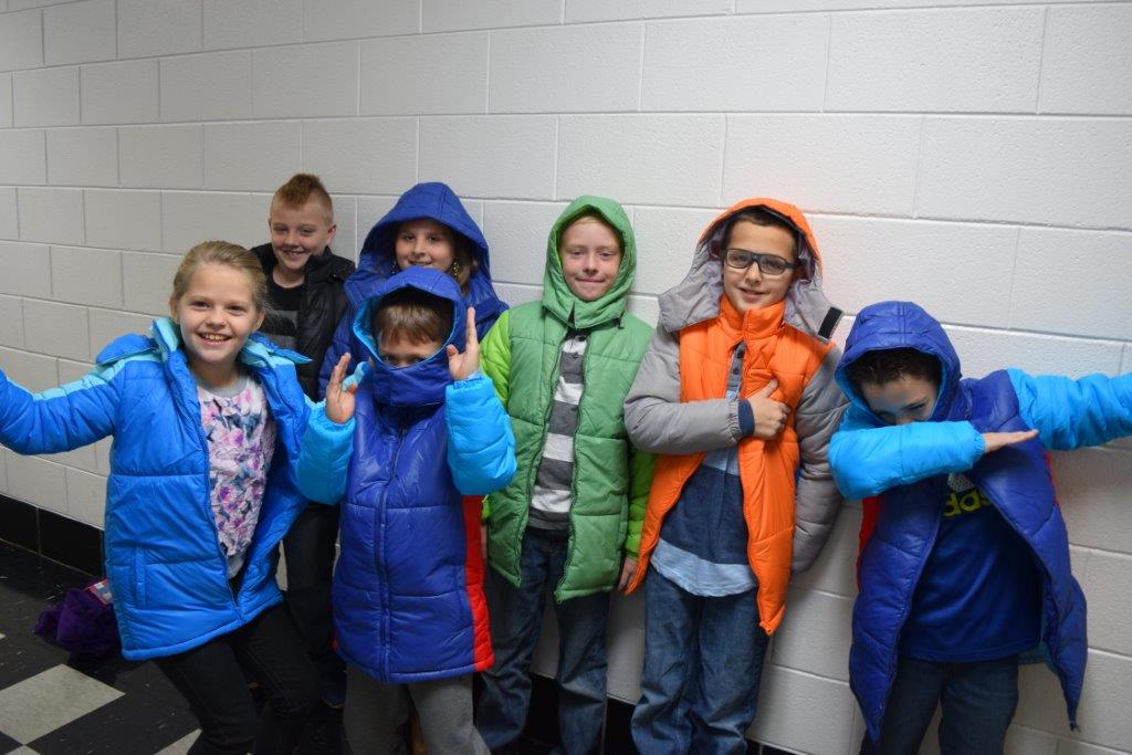 Elementary school students wearing new winter coats provided by the Americans Helping Americans Wellness Programs.