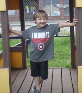 R.J., a young student at the Super WHY literacy camp in West Virginia, smiles while playing outdoors.