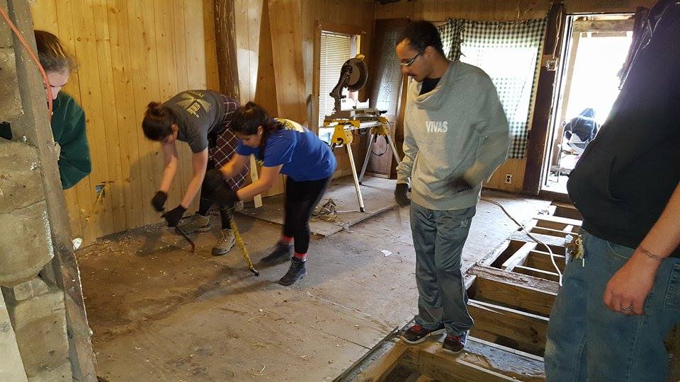 University of Richmond students tearing out old floor at the old cabin at Berwind Lake.