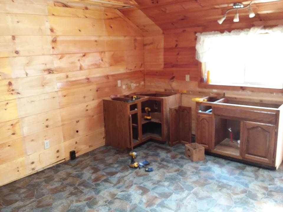 A newly renovated kitchen with wood paneled walls and new cabinets for a veteran's family in rural Tennessee.