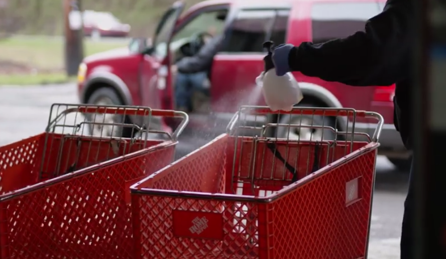 Volunteer sanitizes shopping carts before distributing food to families during the COVID-19 pandemic in Appalachia