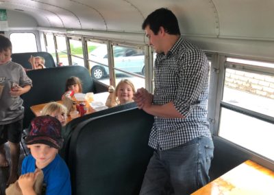 Children receiving nutritious meals on a converted school bus as part of a modified summer feeding program.