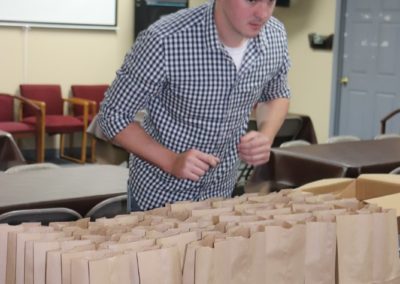 A volunteer organizes brown bag lunches for children in Appalachia to address food insecurity during COVID-19.