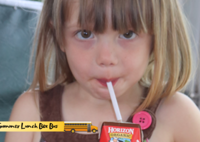 A young girl in rural Tennessee drinks a carton of milk provided by the Summer Lunch Box Bus program.