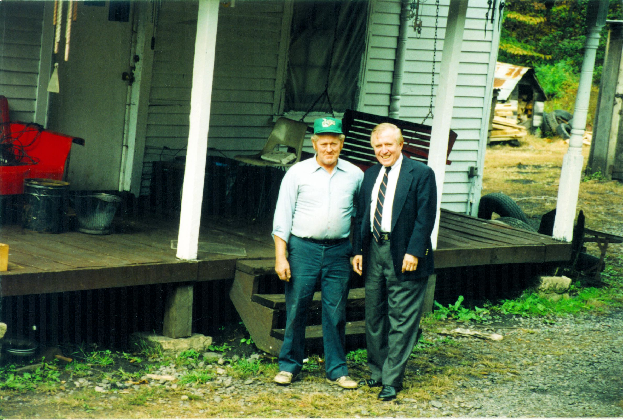 Founder of Americans Helping Americans standing on the porch of a rural Appalachian home with a recipient of a home repair.