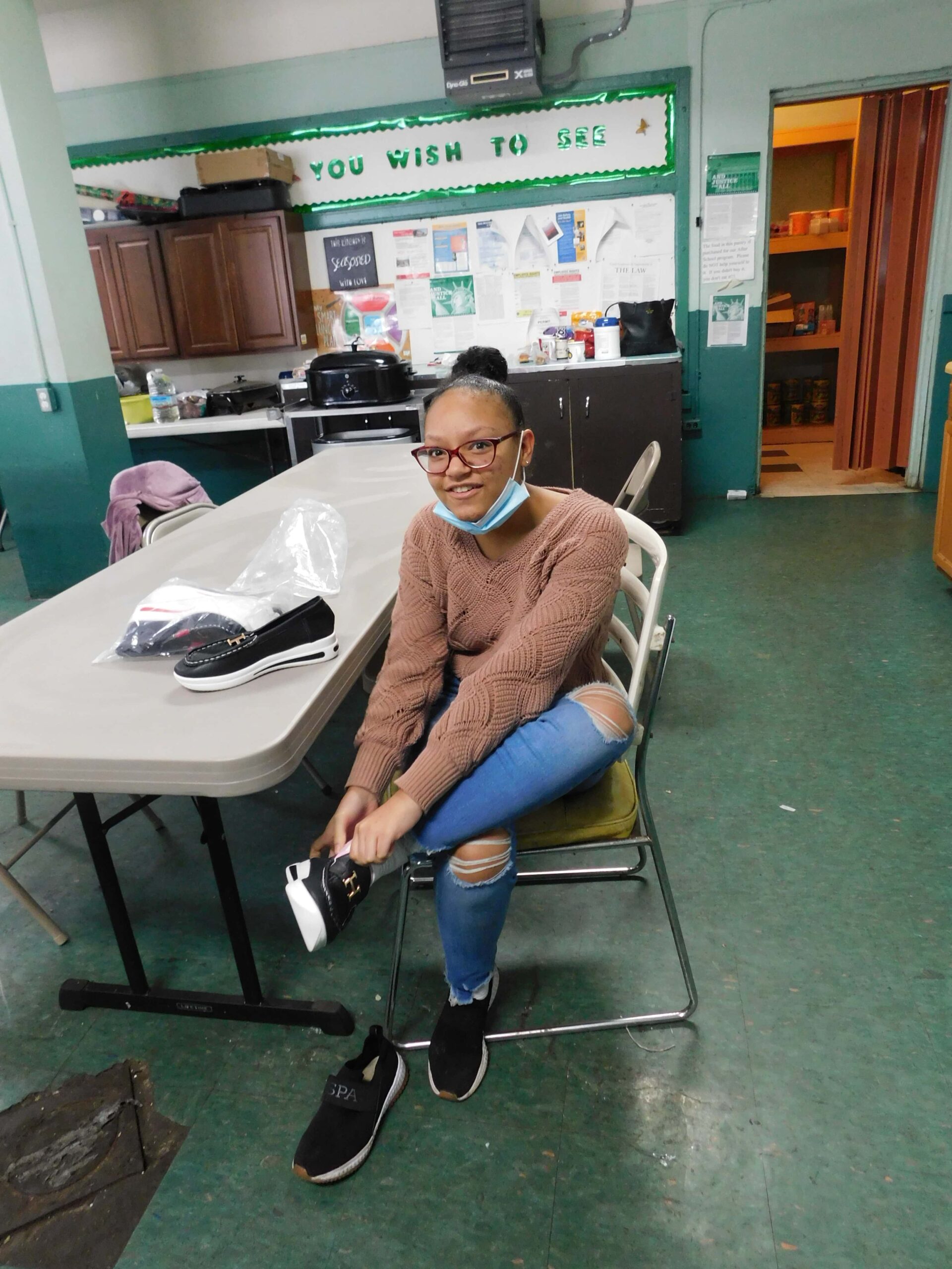 Student in McDowell County WV receiving new shoes provided by Big Creek People in Action and Americans Helping Americans.