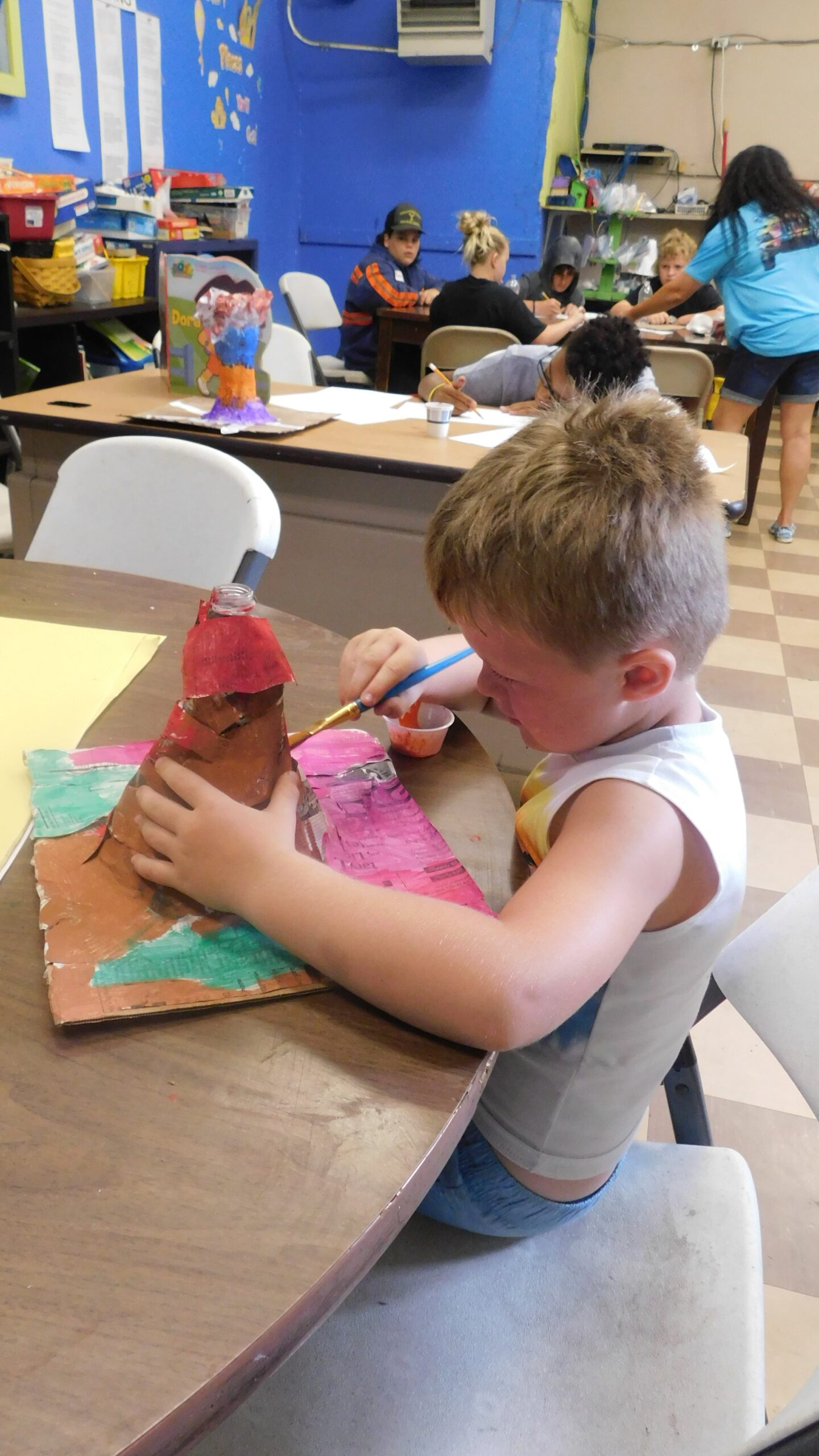 A young camper paints a handmade volcano model during summer camp activities in McDowell County, WV.
