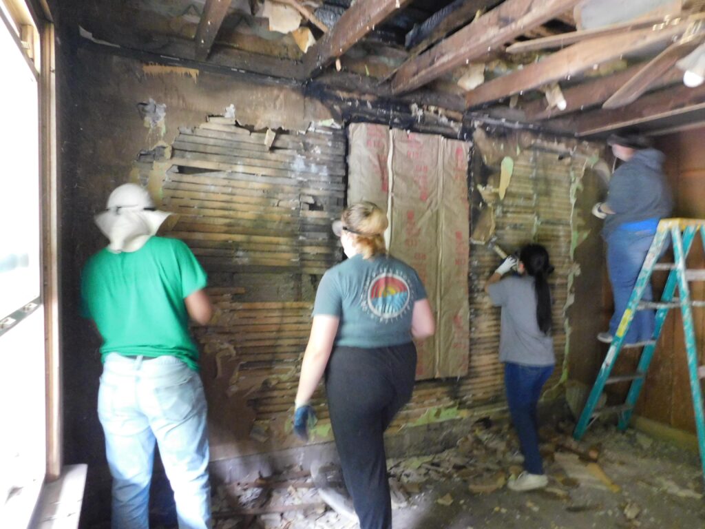 Volunteers for Big Creek People in Action tear out fire-damaged walls to rebuild a home in McDowell County, WV.