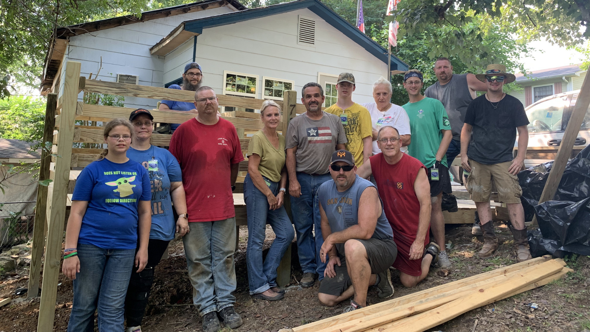 Group of volunteers posing in front of a newly built wooden ramp for a home in Appalachia.