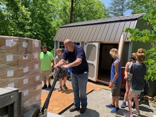 Volunteers unload a pallet of food boxes at a community pantry in Appalachia to support families and seniors.
