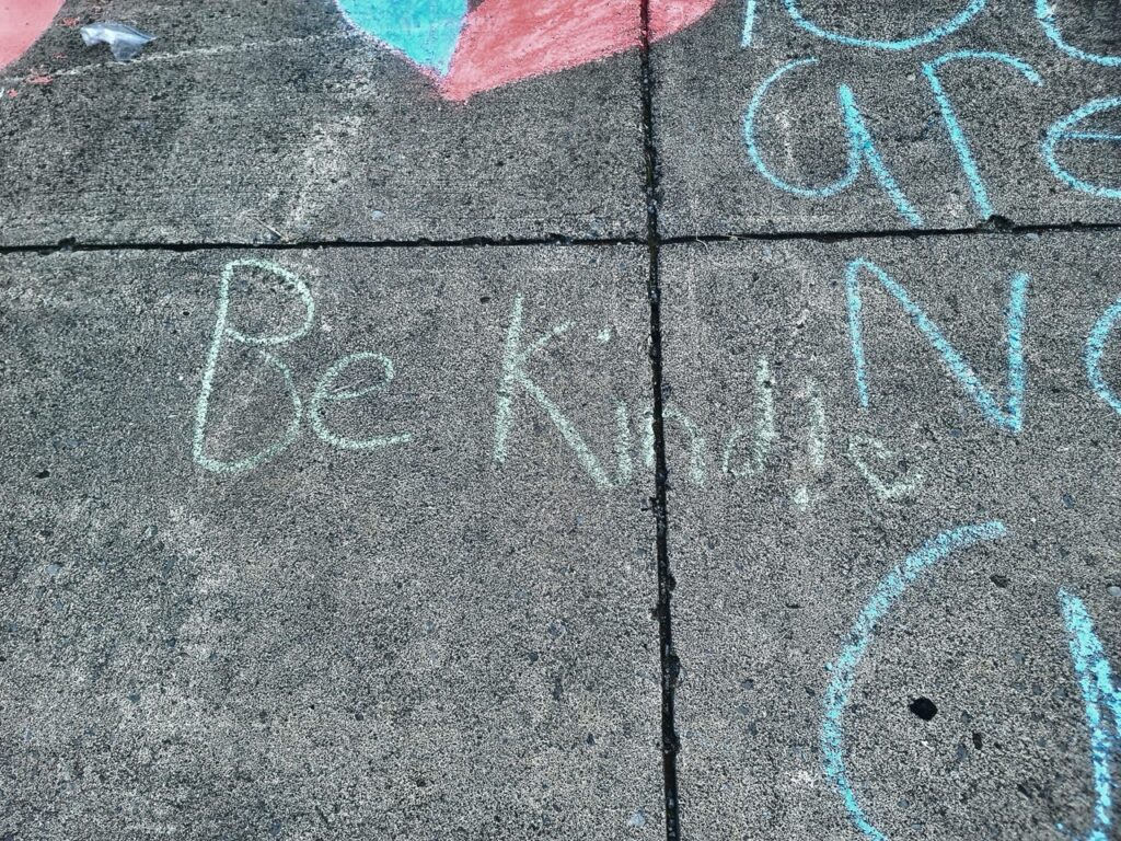 Sidewalk chalk message “Be Kind” at a community home rehab project in Appalachia.