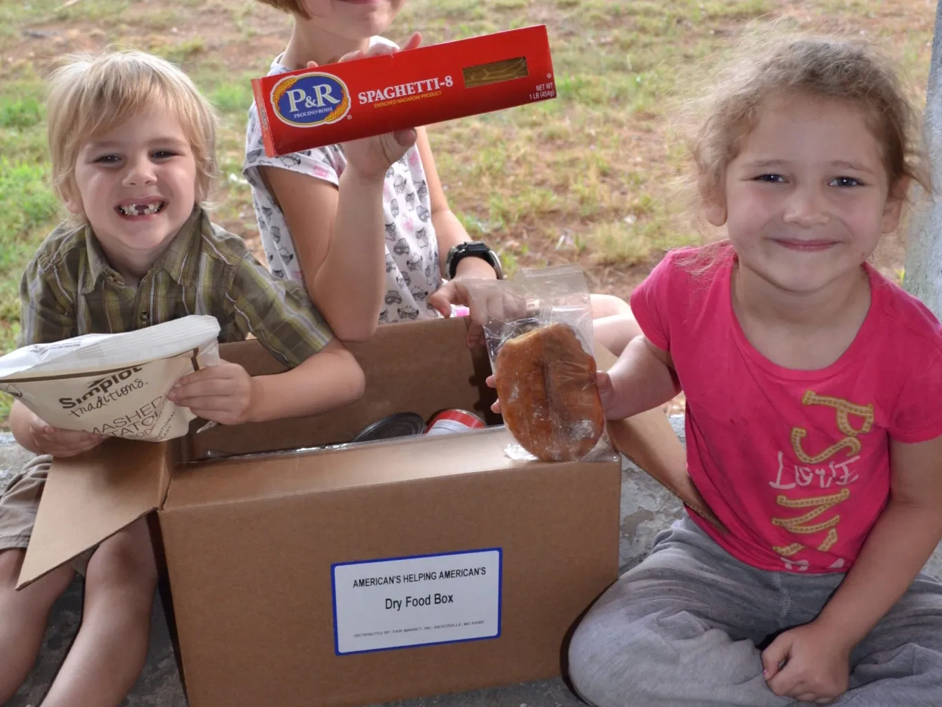 Children receiving food boxes from Americans Helping Americans.