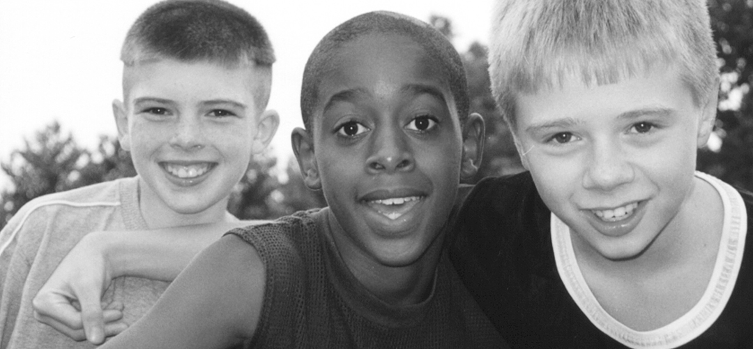 Three smiling children symbolizing the youth and community Americans Helping Americans® is committed to supporting.