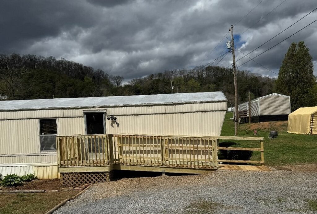 Finished mobile home with a sturdy new wooden ramp and deck built through Americans Helping Americans support.