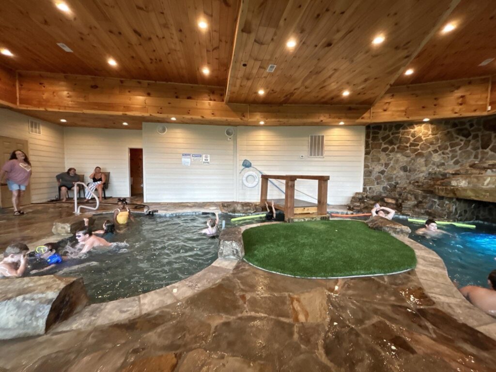Campers swimming in an indoor pool at a Smoky Mountains cabin during their first-ever summer vacation away from home.