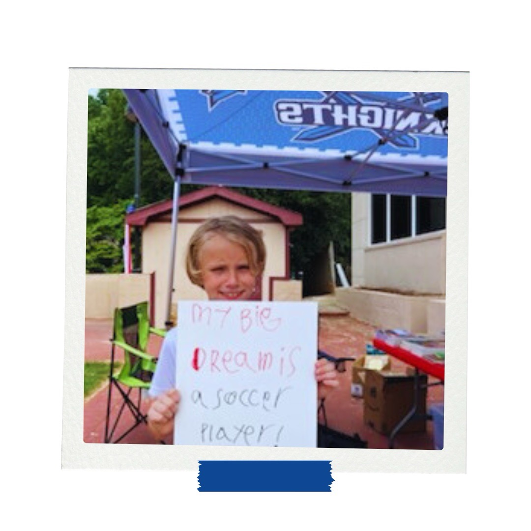 LAMP afterschool student holds vision board reading “My big dream is a soccer player” at a goal-setting event.