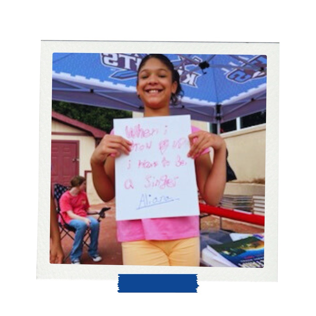 LAMP afterschool student holds a vision board saying she wants to be a singer during goal-setting in Gainesville, Georgia.