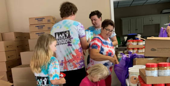 Volunteers pack food donations into bags at an Appalachian food bank distribution.