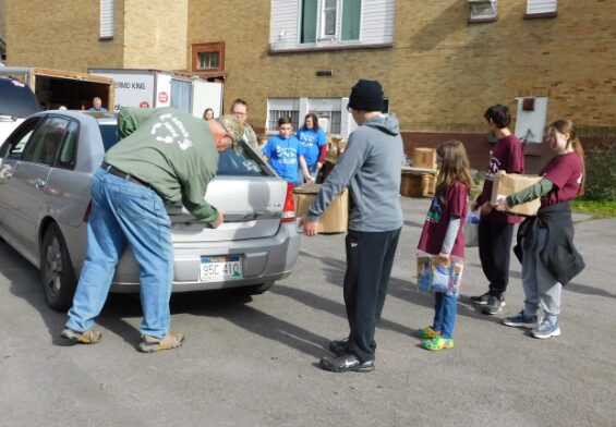 Volunteers load food boxes into a car at an Appalachian food bank distribution.
