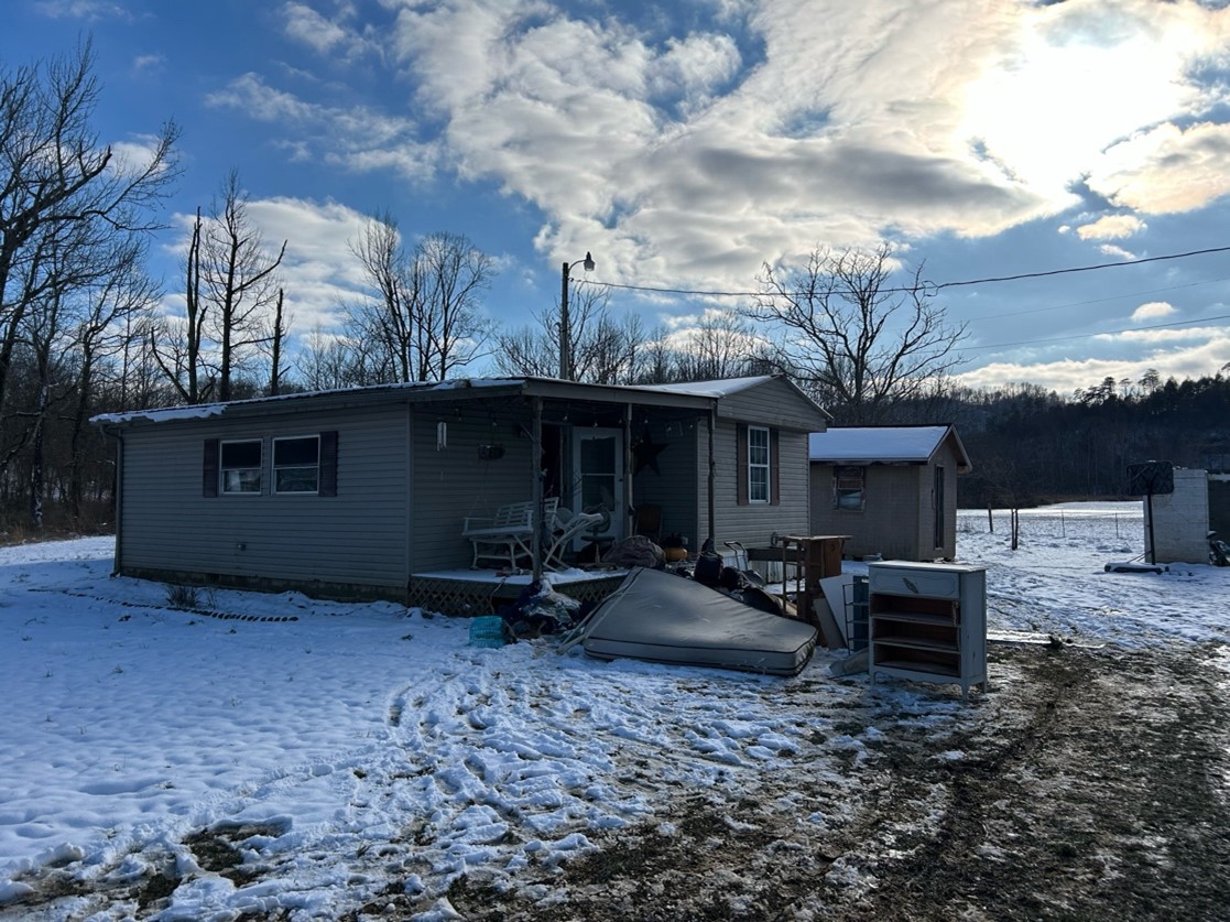 Flood-damaged Appalachian home in winter with ruined furniture outside after historic storm