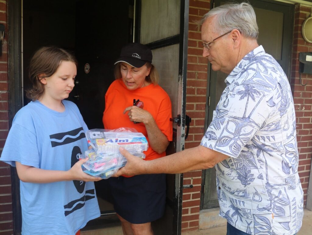 Volunteers delivering Americans Helping Americans Mighty Molars dental kit to Appalachian youth at their front door.