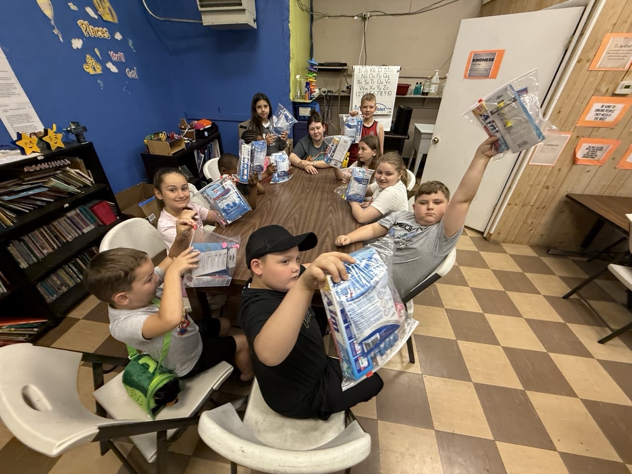 Children at BCPIA proudly holding up Mighty Molars dental kits from Americans Helping Americans after summer program lesson.