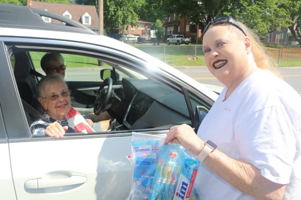 Rene Steele handing Mighty Molars dental kits from Americans Helping Americans to seniors in drive-through distribution.