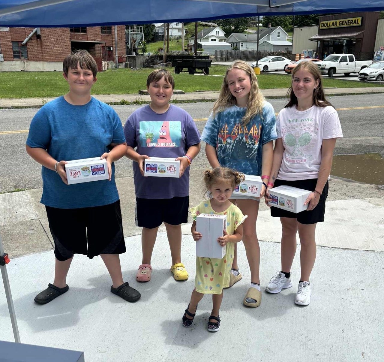 Children in Appalachia hold summer food boxes from Americans Helping Americans program.