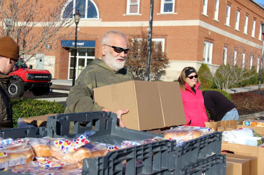 Appalachian man lifting food boxes 