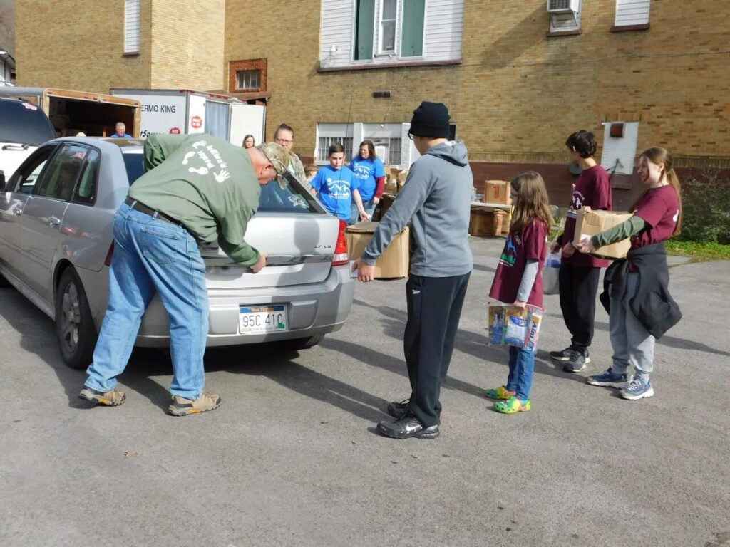 Volunteers load food boxes into a car at a community event in Appalachia. 