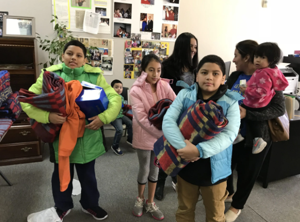 Children and families receive warm blankets and winter supplies at a community support center.