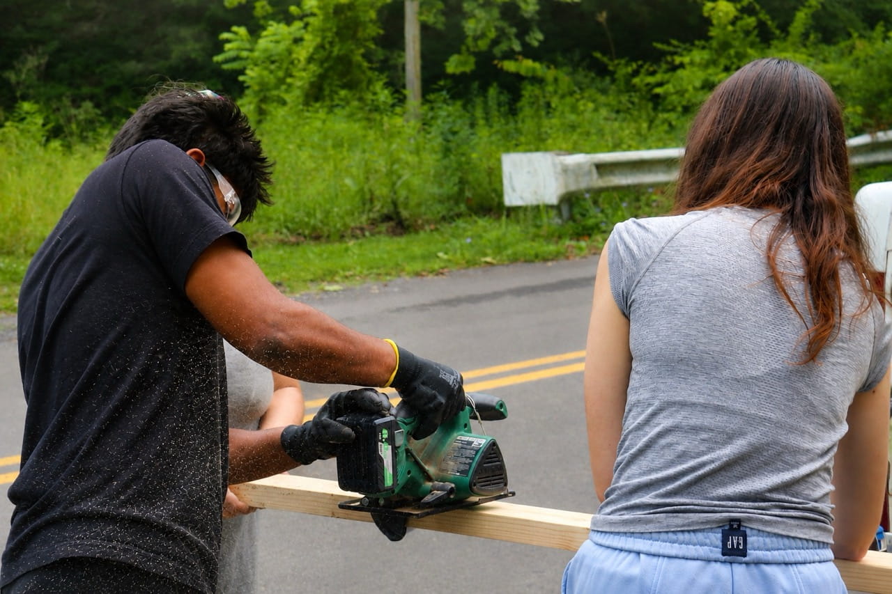 Sidwell Friends School volunteers cutting lumber during a home repair project supported by Americans Helping Americans in West Virginia