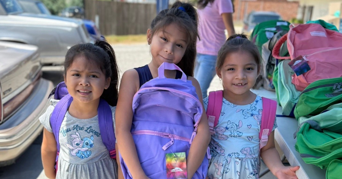 Children in Appalachia proudly hold new backpacks filled with school supplies provided by Americans Helping Americans before the start of the school year